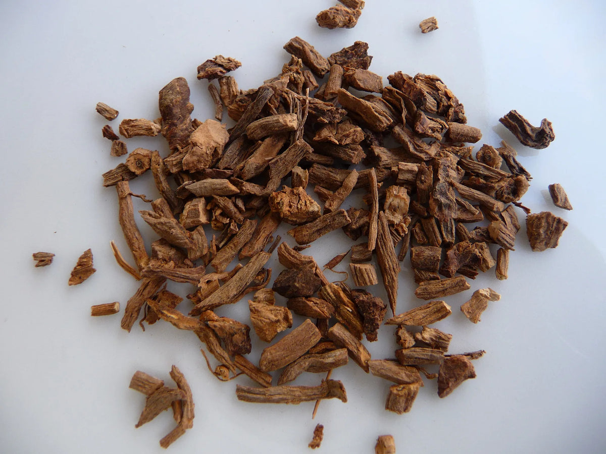 Pile of dried, cut valerian root (Valeriana officinalis) pieces on a white surface
